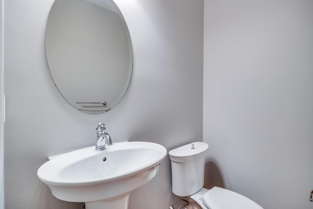 half bathroom featuring a sink and toilet