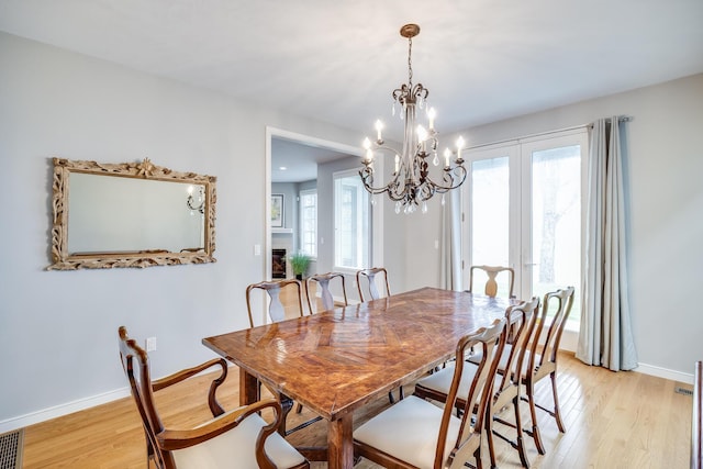 dining room with light wood-style floors, baseboards, and healthy amount of natural light
