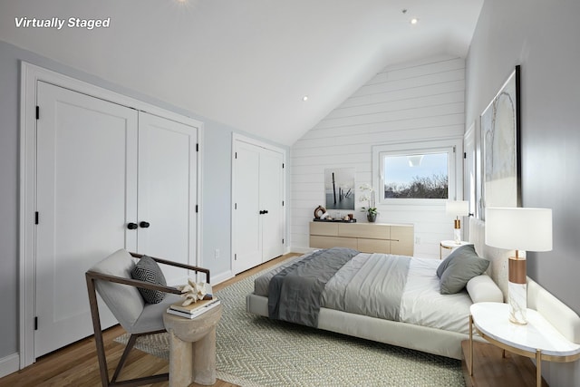 401 Main St Unit 201, West Dennis, MA 02670 - bedroom with recessed lighting, multiple closets, wood finished floors, wooden walls, and lofted ceiling
