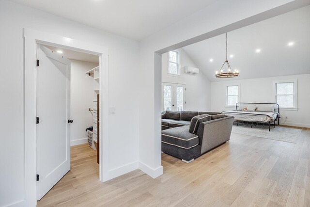 115 Kiahs Way E, Sandwich, MA 02537 - living area with a wall mounted air conditioner, a chandelier, light wood-type flooring, french doors, and high vaulted ceiling