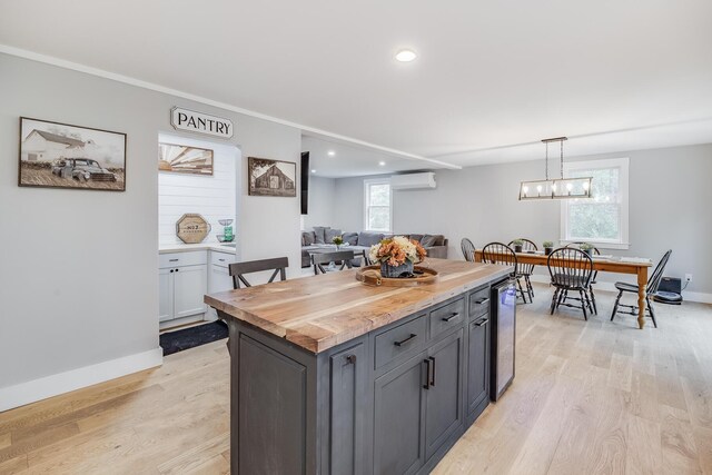 115 Kiahs Way E, Sandwich, MA 02537 - kitchen featuring a wall mounted AC, light wood-type flooring, a kitchen island, recessed lighting, and baseboards