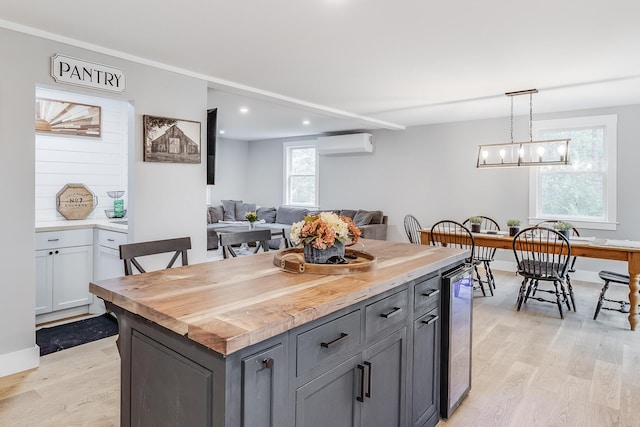 115 Kiahs Way E, Sandwich, MA 02537 - kitchen featuring a wall mounted air conditioner, light wood-style flooring, beverage cooler, decorative light fixtures, and gray cabinets