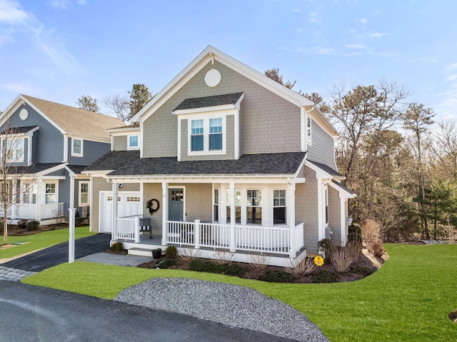 view of front of property featuring a shingled roof, covered porch, a garage, driveway, and a front lawn