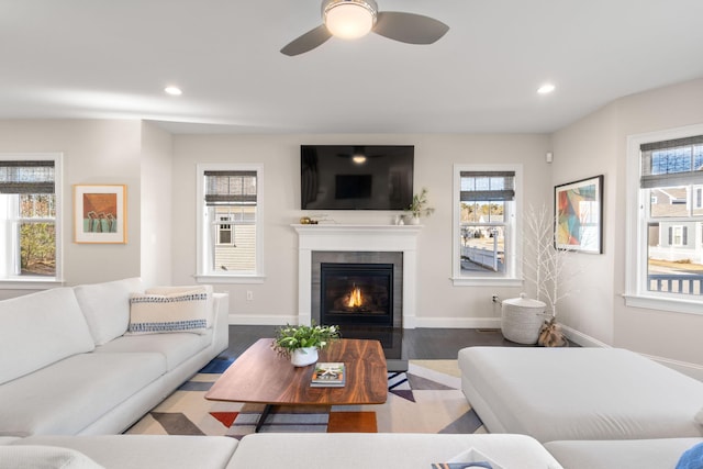 living room featuring recessed lighting, a fireplace, baseboards, and wood finished floors