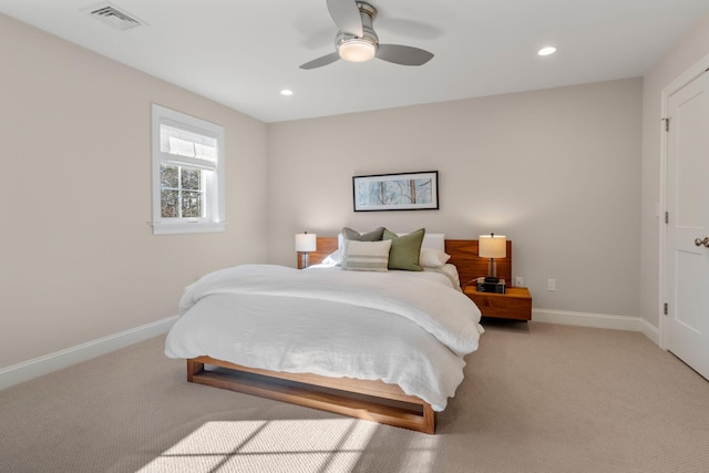 bedroom with baseboards, visible vents, and light colored carpet