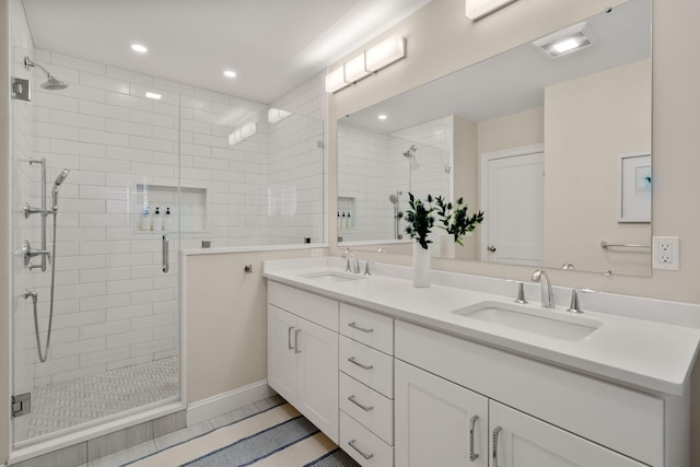 full bath featuring a stall shower, a sink, recessed lighting, and double vanity