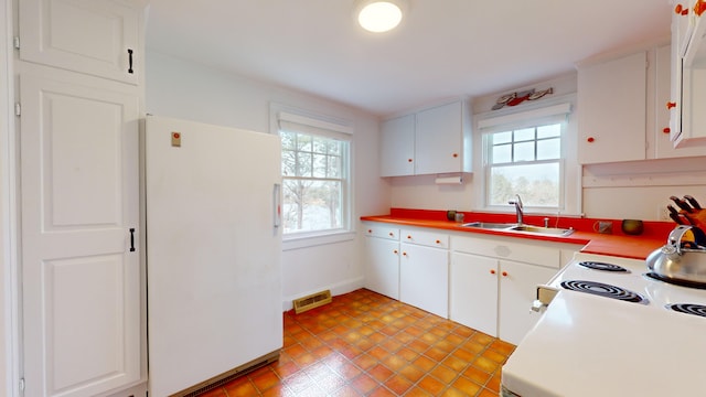 kitchen with sink, white cabinetry, and white fridge