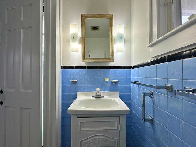 bathroom with vanity and tile walls