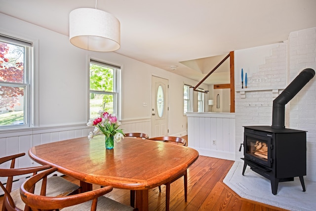10 Bay View Rd, Wellfleet, MA 02667 - dining space featuring a wood stove, light wood-style floors, and a wainscoted wall