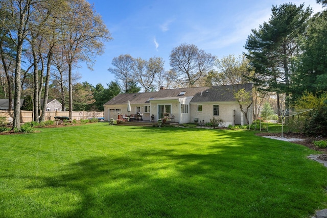 rear view of house with an attached garage, a deck, and a chimney