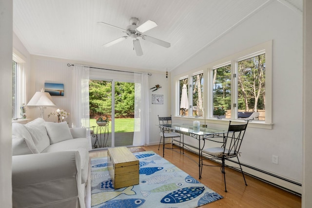 sunroom featuring a baseboard radiator, plenty of natural light, and lofted ceiling