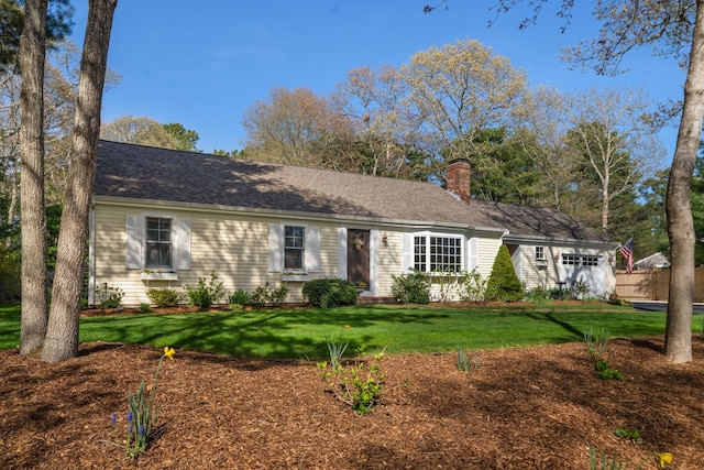 ranch-style home with an attached garage, a chimney, and a front yard