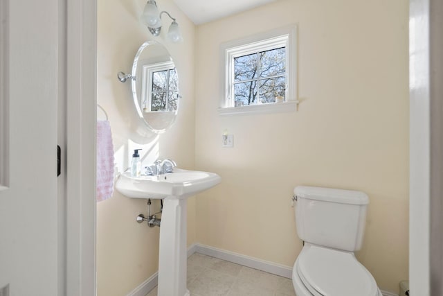 half bath featuring toilet, baseboards, and tile patterned floors