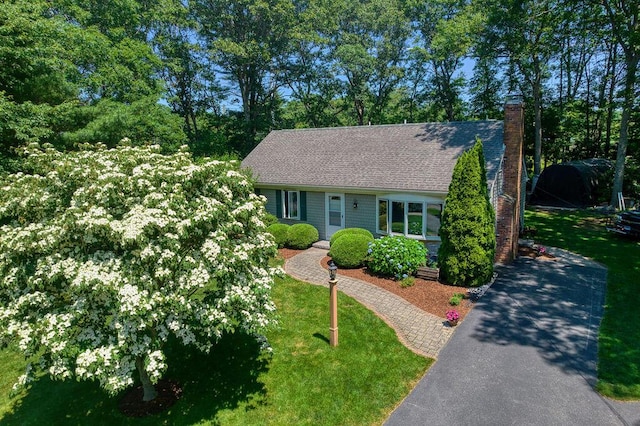 76 Kiahs Way E, Sandwich, MA 02537 - view of front of home featuring a front yard, a chimney, a shingled roof, and driveway