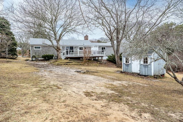 view of front of home with a shed, a chimney, and an outdoor structure