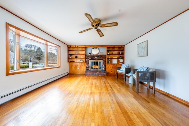 unfurnished living room with a brick fireplace, light wood-style flooring, a baseboard heating unit, and ceiling fan