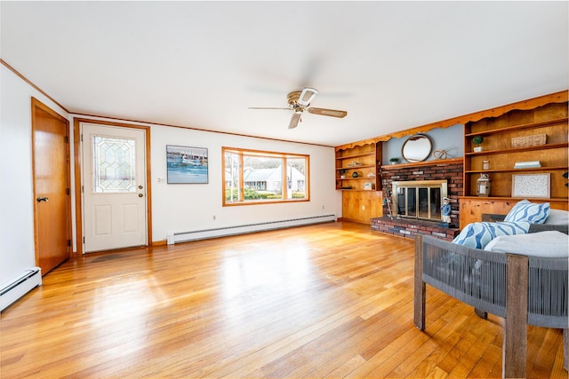 living area featuring a baseboard heating unit, a fireplace, light wood-style flooring, and a ceiling fan