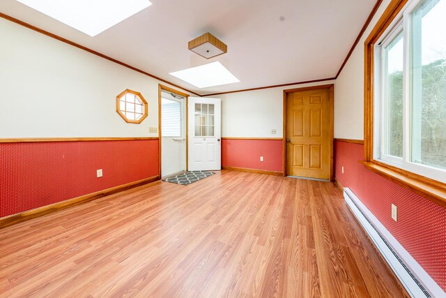 2 Pine Ridge End, Truro, MA 02666 - spare room featuring a skylight, a baseboard radiator, light wood-style floors, wainscoting, and crown molding