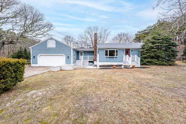 ranch-style home with driveway, a chimney, and a front yard