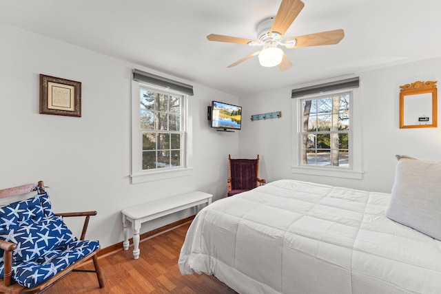 bedroom featuring multiple windows, hardwood / wood-style floors, and ceiling fan