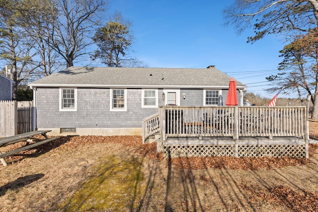 back of property with a wooden deck and a lawn