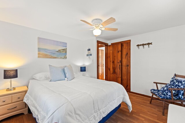 bedroom with ceiling fan, dark hardwood / wood-style flooring, and a closet