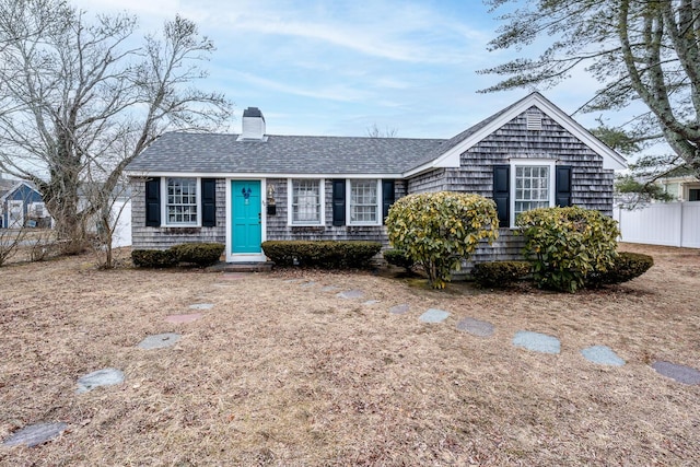 single story home featuring a shingled roof, a chimney, and fence