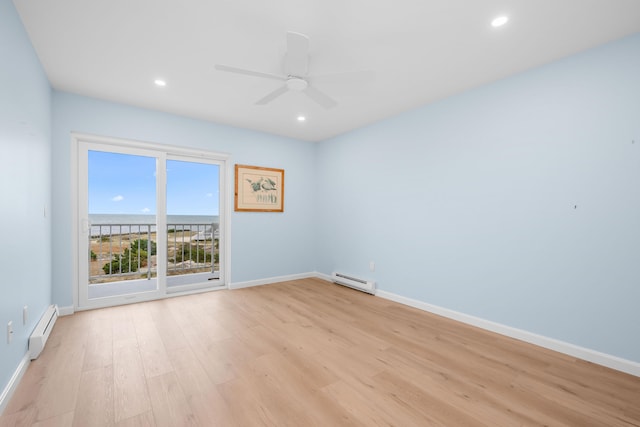 unfurnished room featuring ceiling fan, light hardwood / wood-style flooring, and a baseboard heating unit