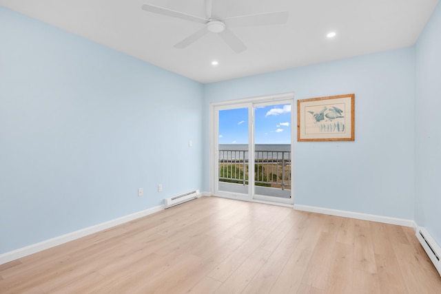 empty room with light wood-type flooring, ceiling fan, and a baseboard heating unit