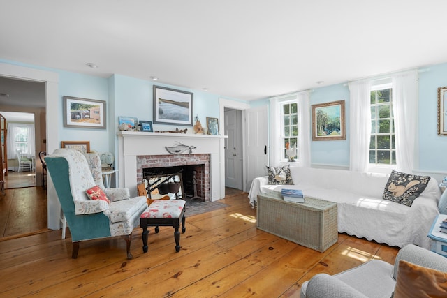 73 Division St, West Harwich, MA 02671 - living area with a brick fireplace, healthy amount of natural light, and hardwood / wood-style floors