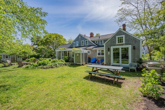 73 Division St, West Harwich, MA 02671 - rear view of house featuring a chimney and a lawn