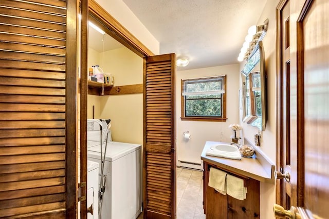 laundry room with washing machine and dryer, baseboard heating, and light tile patterned flooring
