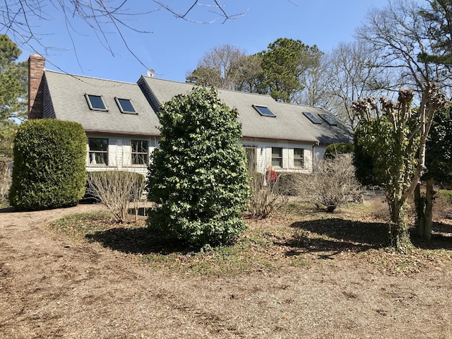view of front of property with a chimney and roof with shingles
