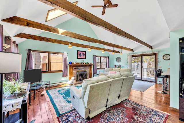 living room with a brick fireplace, a ceiling fan, and hardwood / wood-style flooring