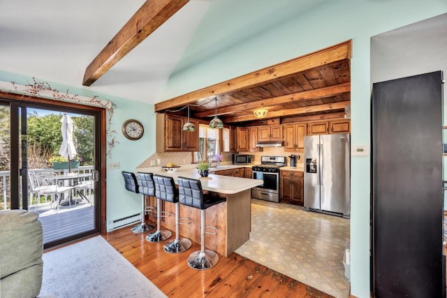 kitchen featuring appliances with stainless steel finishes, beam ceiling, a baseboard heating unit, light countertops, and a peninsula