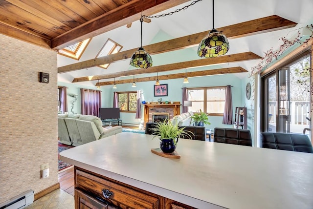 kitchen with a baseboard heating unit, open floor plan, a fireplace, light countertops, and hanging light fixtures