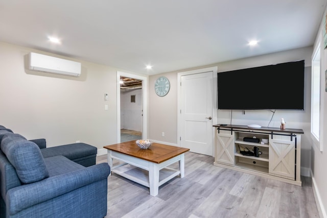 living room featuring light hardwood / wood-style flooring and a wall unit AC