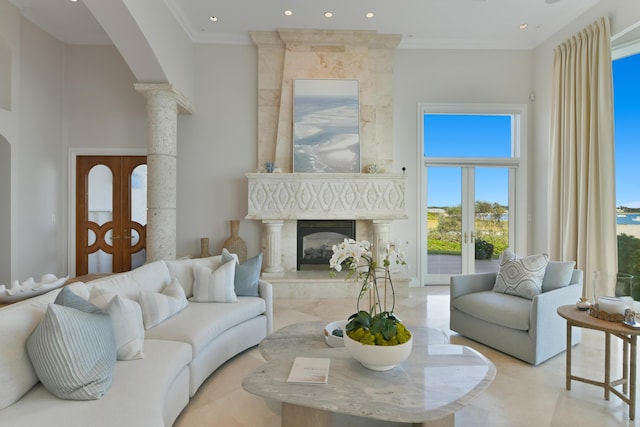 living room featuring a fireplace, crown molding, a towering ceiling, and french doors