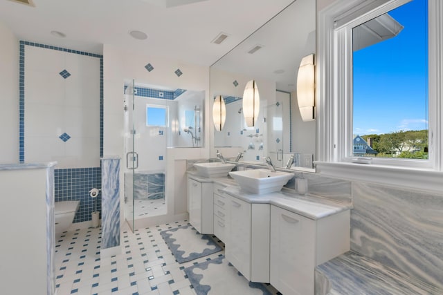 bathroom with vanity, walk in shower, tile walls, and tile patterned floors