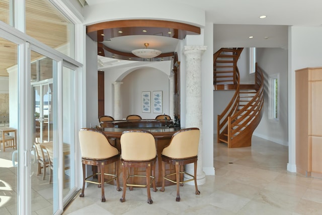 dining area with bar area and ornate columns