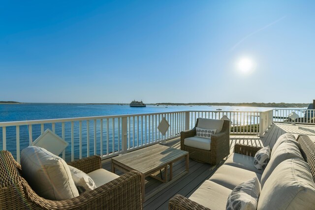 wooden terrace with an outdoor living space and a water view