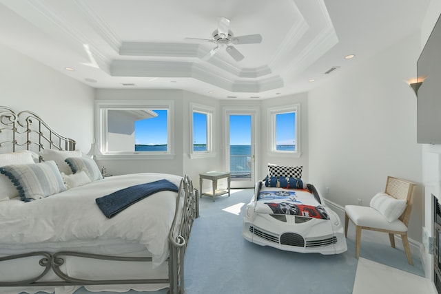 carpeted bedroom with ceiling fan, ornamental molding, and a raised ceiling