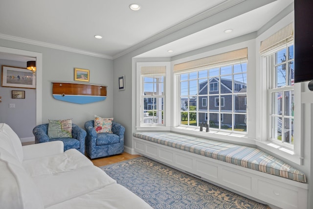 sitting room with light hardwood / wood-style flooring and ornamental molding