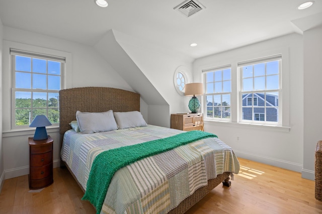 bedroom with multiple windows and hardwood / wood-style floors