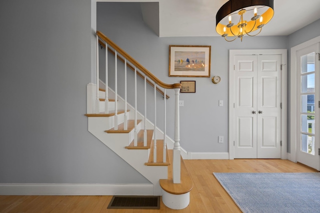 entryway featuring wood-type flooring and an inviting chandelier