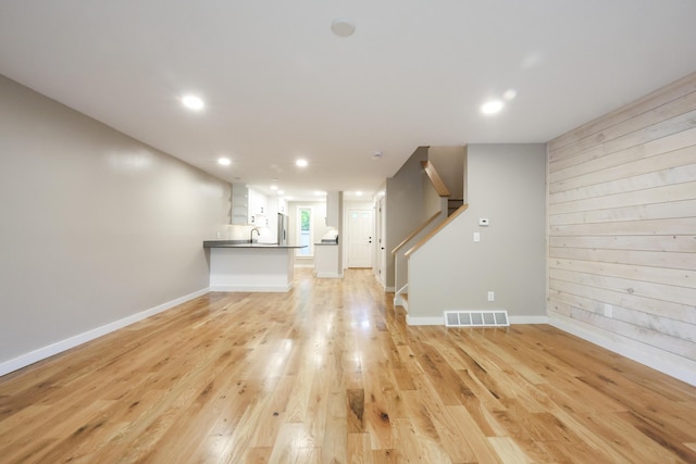 300 Buck Island Rd Unit C13F, West Yarmouth, MA 02673 - unfurnished living room with light wood-style flooring, stairs, recessed lighting, baseboards, and a sink