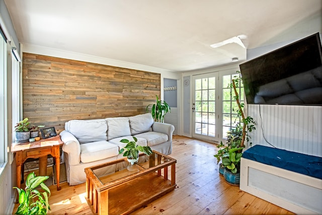 living room with light hardwood / wood-style flooring and wooden walls