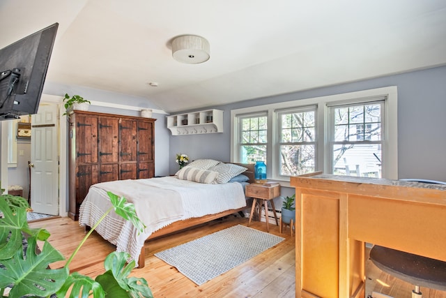 bedroom featuring light hardwood / wood-style flooring and vaulted ceiling