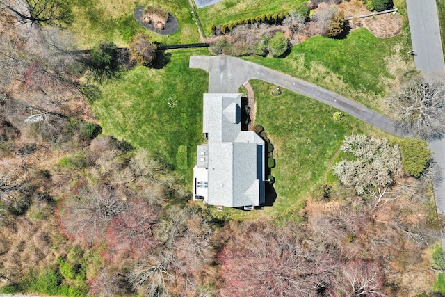 rear view of property featuring a chimney, a wooden deck, a yard, and roof with shingles