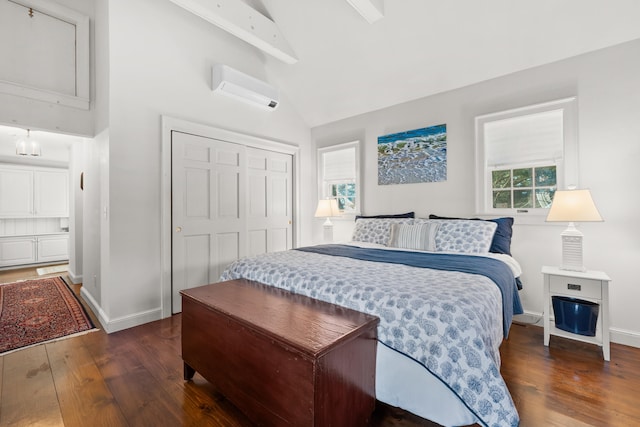 bedroom featuring lofted ceiling, baseboards, an AC wall unit, a closet, and wood-type flooring